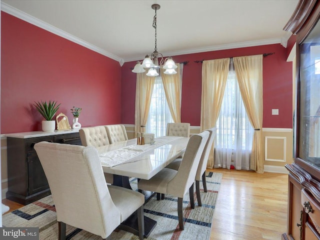 dining area featuring an inviting chandelier, crown molding, and light hardwood / wood-style floors