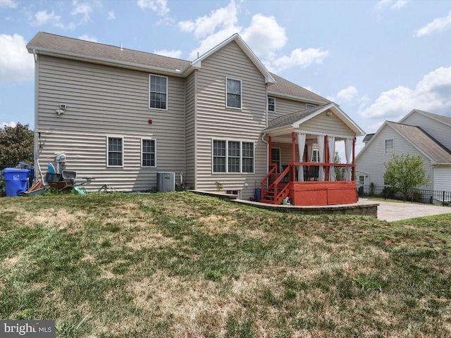 rear view of property featuring a lawn