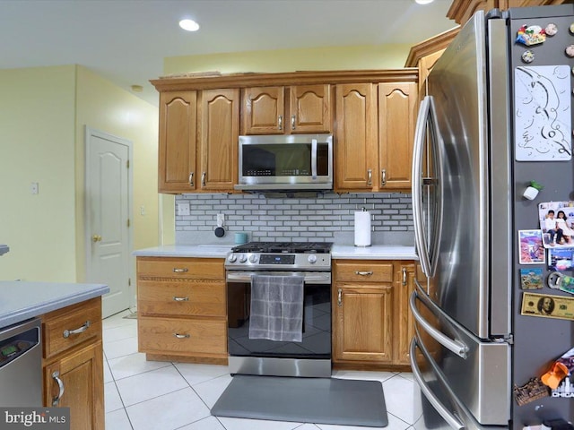 kitchen featuring appliances with stainless steel finishes, light tile patterned floors, and backsplash