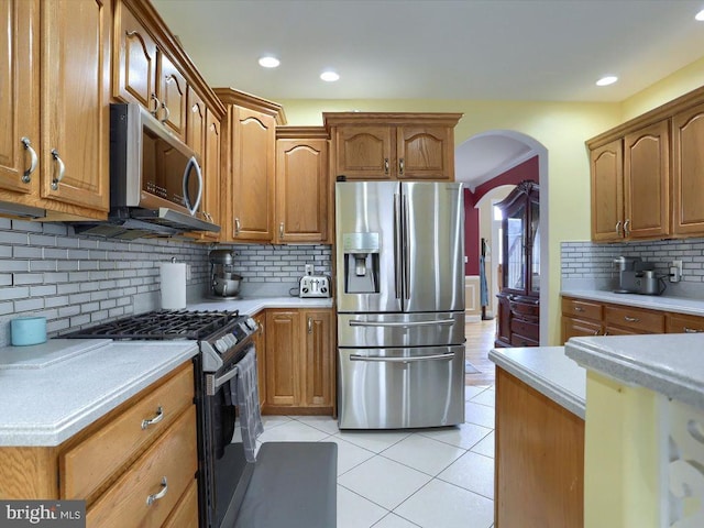 kitchen featuring stainless steel appliances, tasteful backsplash, and light tile patterned floors