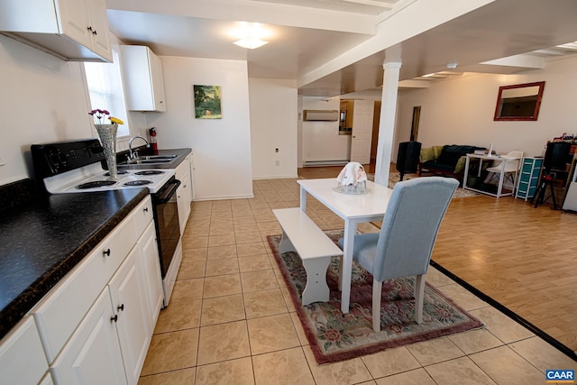 kitchen with sink, light tile patterned floors, electric range, white cabinets, and ornate columns