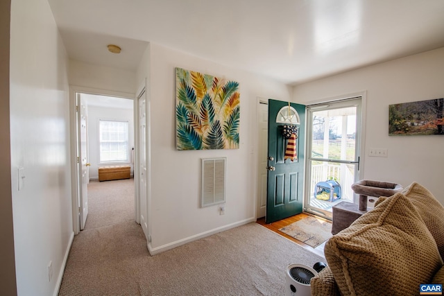 foyer with light colored carpet and a wealth of natural light