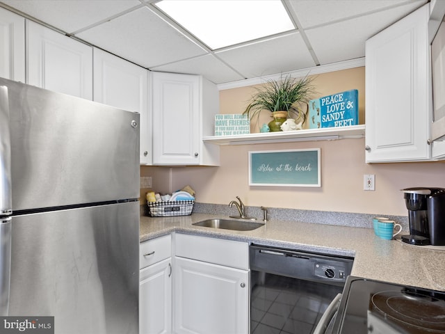 kitchen featuring a paneled ceiling, appliances with stainless steel finishes, sink, and white cabinets