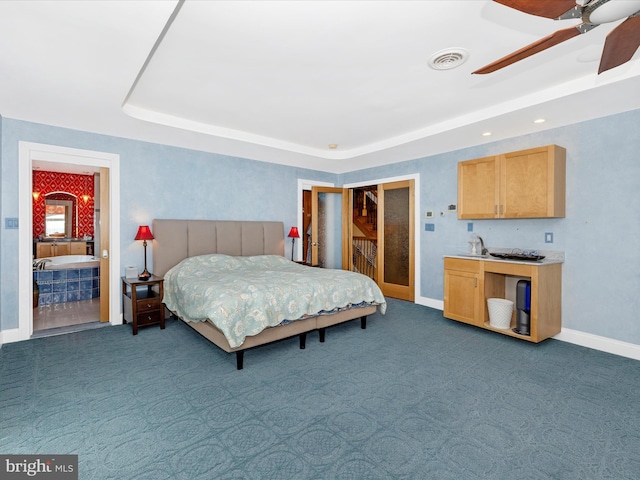 carpeted bedroom featuring a raised ceiling, sink, and ceiling fan