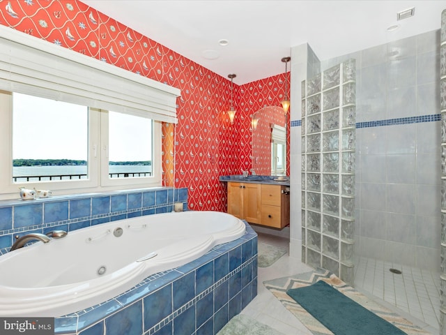 bathroom featuring a water view, tile patterned floors, vanity, and independent shower and bath