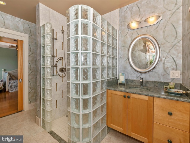 bathroom featuring vanity, tile patterned flooring, and a tile shower