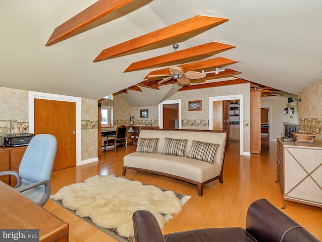 living room with wood-type flooring, lofted ceiling with beams, and ceiling fan