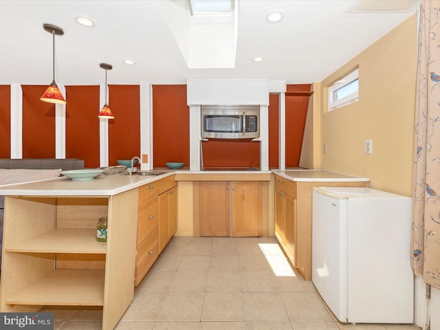 kitchen featuring sink, light tile patterned flooring, decorative light fixtures, kitchen peninsula, and white fridge