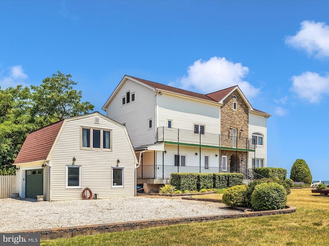 back of property with a balcony and a yard