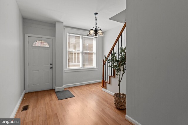 entrance foyer featuring a wealth of natural light, a notable chandelier, and light hardwood / wood-style floors