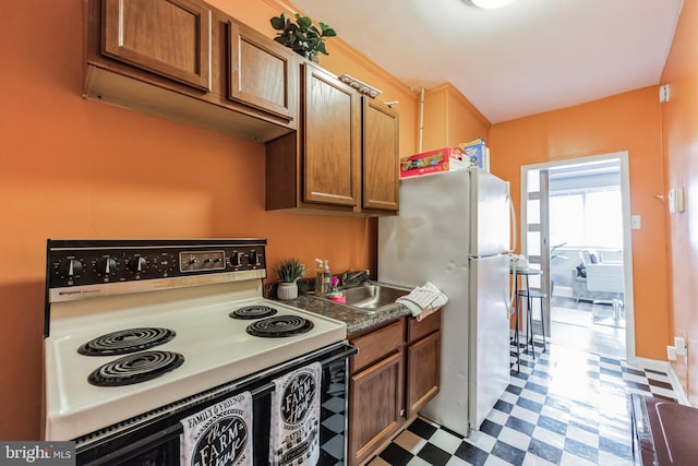 kitchen featuring sink, white appliances, and light tile patterned floors