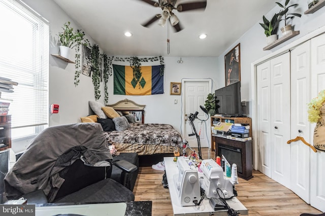 bedroom featuring ceiling fan, light hardwood / wood-style floors, and a closet