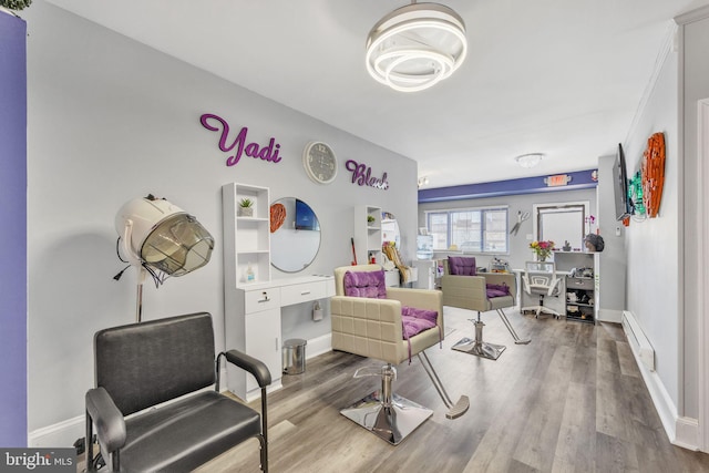 living area with hardwood / wood-style flooring and a baseboard heating unit