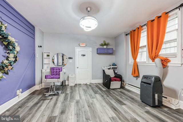 interior space with wood-type flooring and a baseboard heating unit