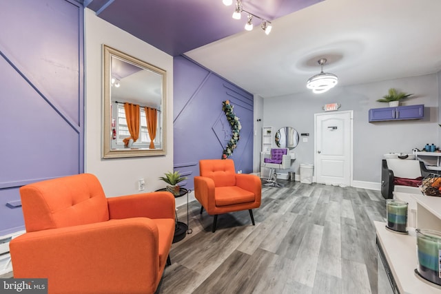 sitting room with hardwood / wood-style flooring and track lighting