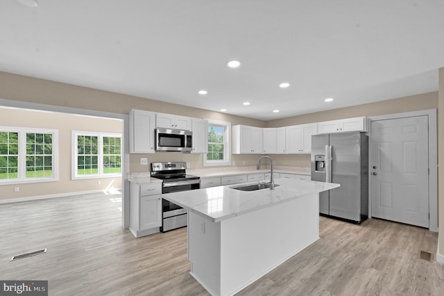 kitchen with appliances with stainless steel finishes, sink, light hardwood / wood-style flooring, and a wealth of natural light