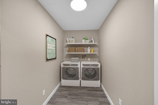 clothes washing area featuring dark wood-type flooring and washer and clothes dryer