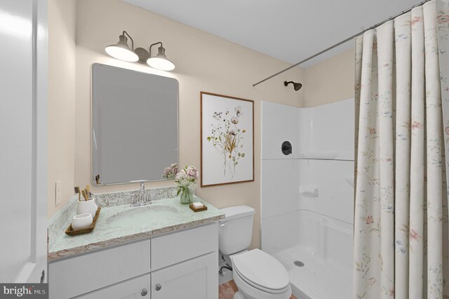 bathroom with curtained shower, toilet, and vanity