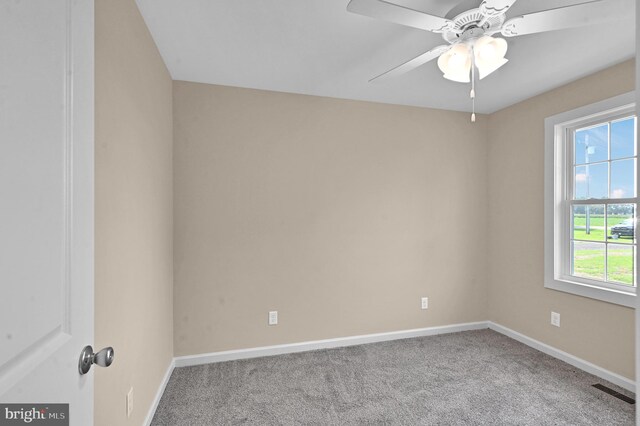 carpeted empty room with ceiling fan and plenty of natural light