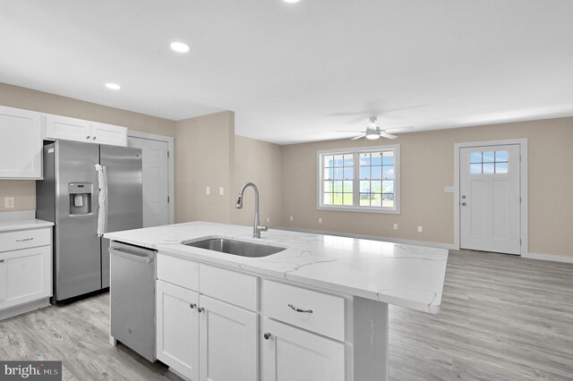 kitchen with stainless steel appliances, light wood-type flooring, an island with sink, ceiling fan, and sink