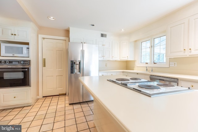 kitchen with white cabinetry, stainless steel appliances, and light tile patterned flooring