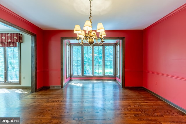 unfurnished dining area with crown molding, dark wood-type flooring, and a chandelier