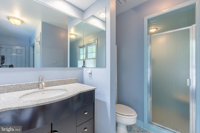 bathroom featuring vanity, an enclosed shower, and toilet