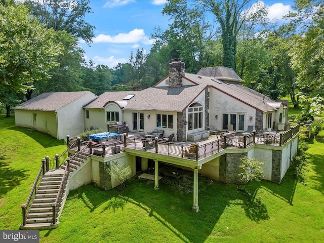 back of house featuring stairs, a lawn, a wooden deck, stucco siding, and a chimney