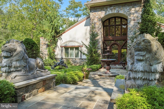 property entrance with stone siding and stucco siding