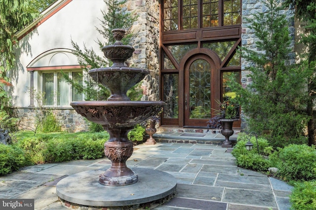 property entrance featuring stone siding and stucco siding