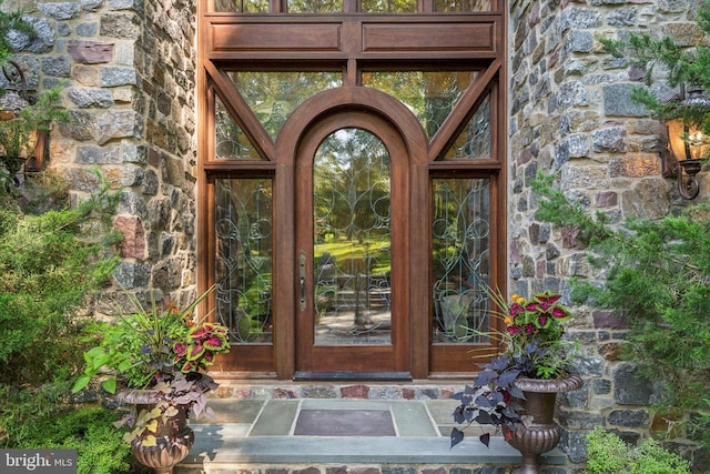 entrance to property featuring stone siding