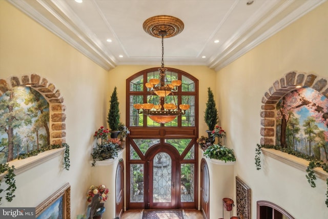 foyer entrance with a chandelier, ornamental molding, and recessed lighting