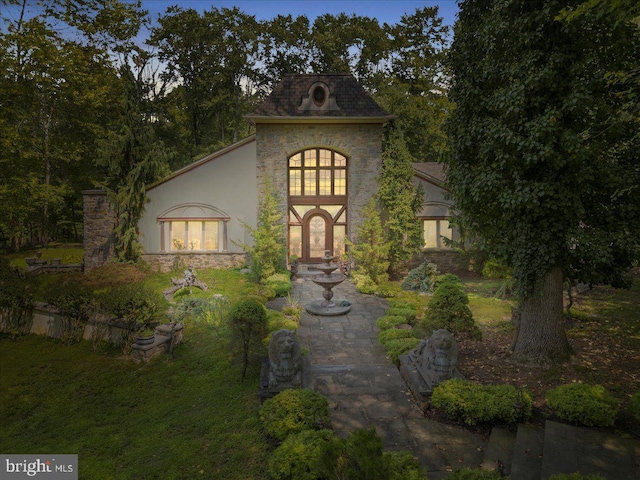 french country home featuring stone siding, french doors, and stucco siding