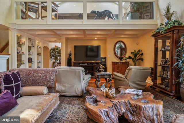 living room featuring arched walkways, coffered ceiling, a fireplace, built in features, and beam ceiling