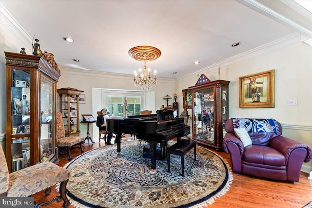 sitting room with ornamental molding, recessed lighting, wood finished floors, and an inviting chandelier