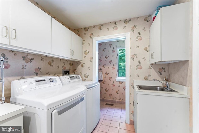 laundry area with wallpapered walls, cabinet space, independent washer and dryer, a sink, and light tile patterned flooring