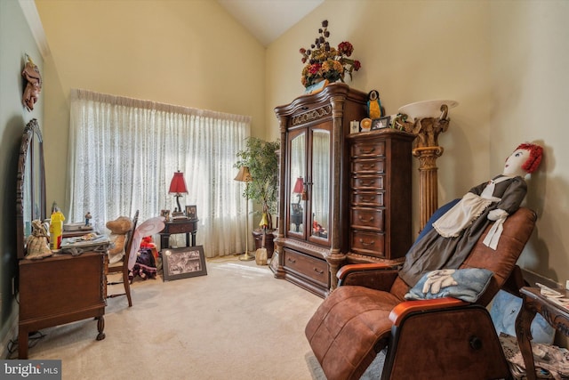 sitting room with vaulted ceiling and carpet flooring