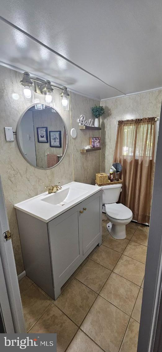 bathroom with vanity, tile patterned flooring, and toilet