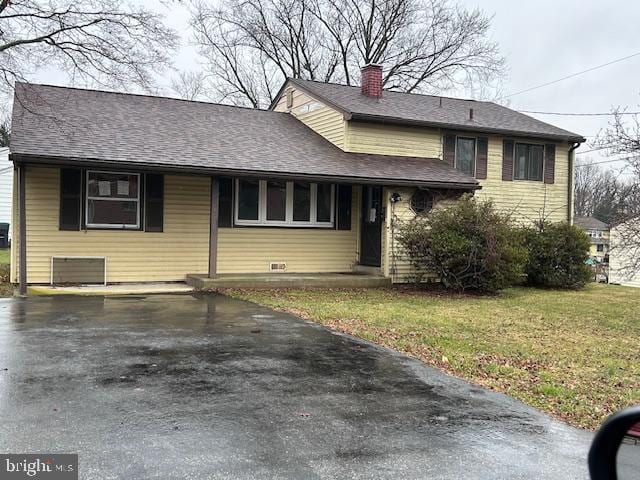 tri-level home with a front yard