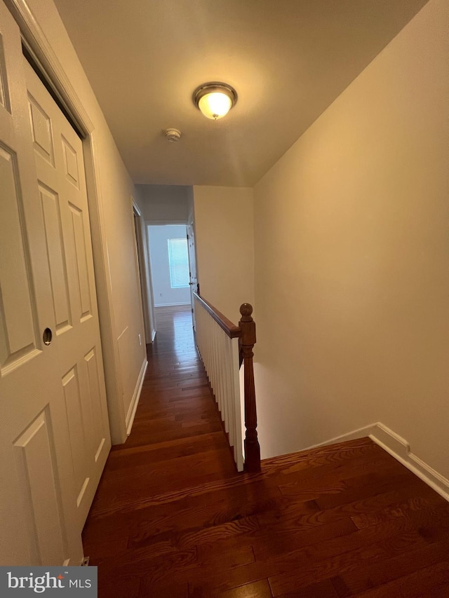 corridor with separate washer and dryer and dark hardwood / wood-style floors