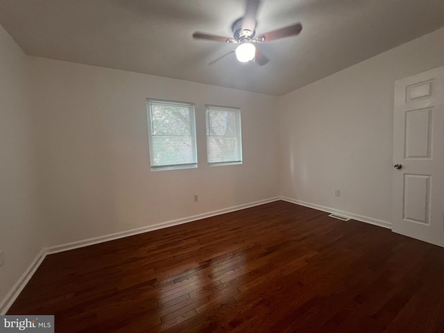 empty room with ceiling fan and dark hardwood / wood-style flooring