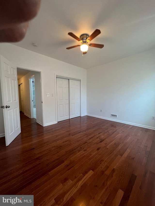 unfurnished bedroom featuring ceiling fan and dark hardwood / wood-style flooring