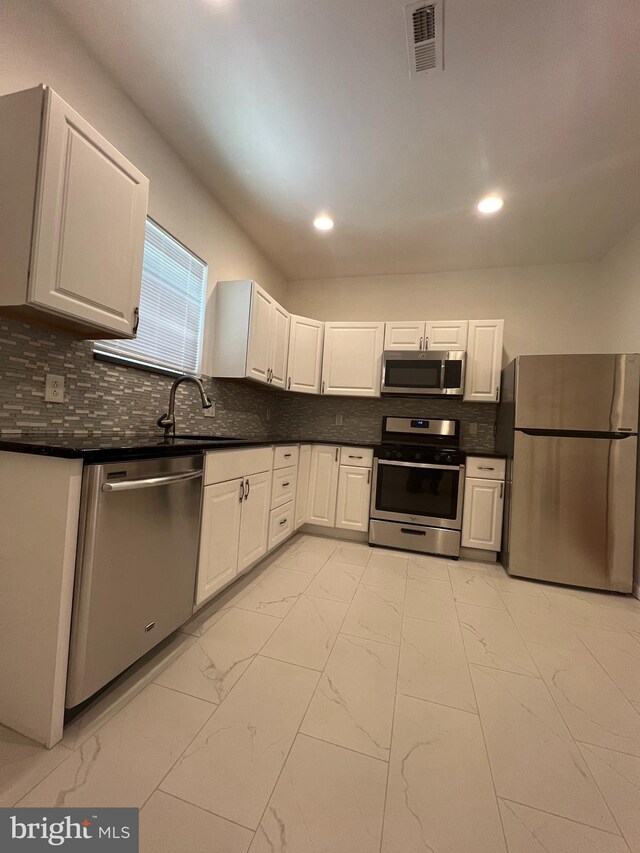 kitchen featuring white cabinets, stainless steel appliances, sink, and tasteful backsplash