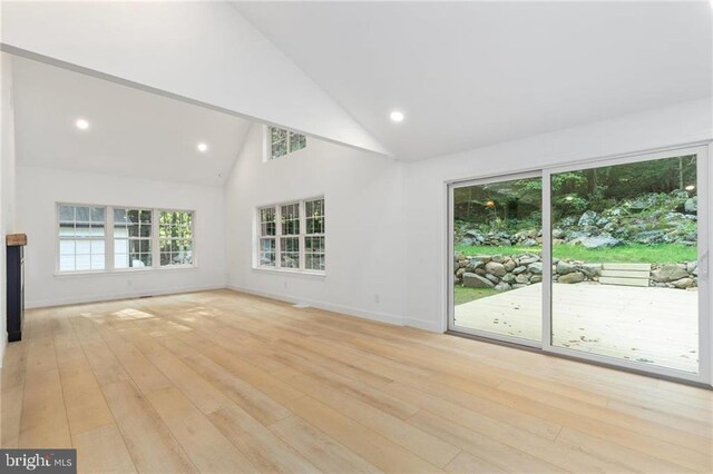 unfurnished living room with light hardwood / wood-style flooring and high vaulted ceiling