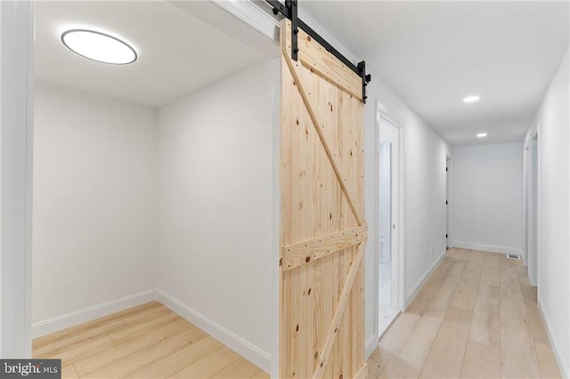 hall featuring light hardwood / wood-style floors and a barn door