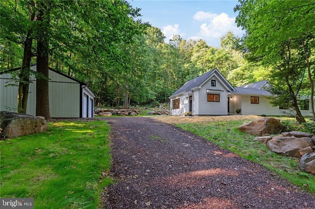 view of yard with a garage and an outbuilding