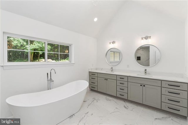 bathroom featuring lofted ceiling, tile patterned floors, a tub to relax in, and dual bowl vanity