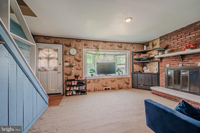 living room with wood walls and light colored carpet