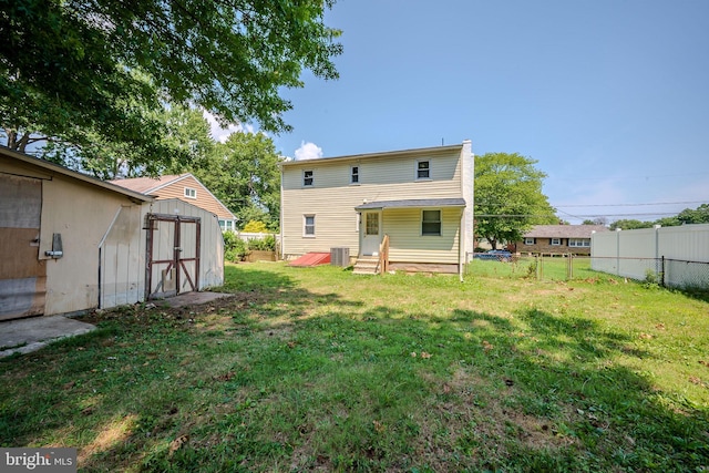 rear view of house with a yard and a storage shed