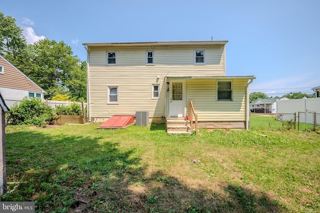 back of property featuring a lawn and cooling unit